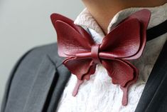 a close up of a person wearing a red bow tie