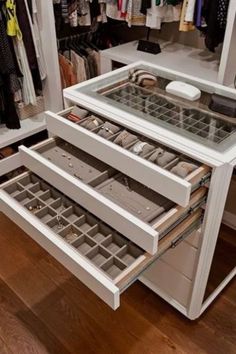 an open drawer in a closet filled with clothes