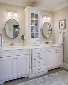 a white bathroom with double sinks and two mirrors on the wall next to each other