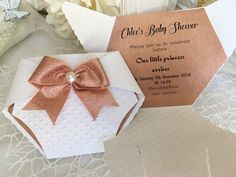 a baby shower is set up on a lace tablecloth with pink and white flowers in the background