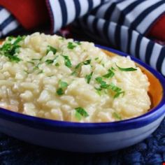 a blue bowl filled with rice and garnished with parsley on the side