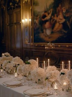 the table is set with white flowers and candles