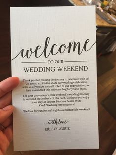 someone holding up a card that says welcome to our wedding weekend