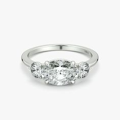 three stone diamond ring in 18k white gold, with an oval brilliant cut center