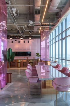 an office with pink chairs and large windows