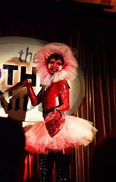 a woman dressed in red and white is standing on stage