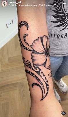 a woman's arm with a flower tattoo on it