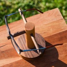 a pair of glasses sitting on top of a wooden table next to a piece of wood