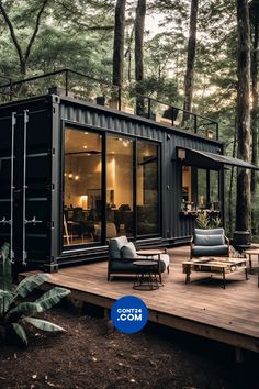 a house made out of shipping containers in the middle of a forest with chairs and tables