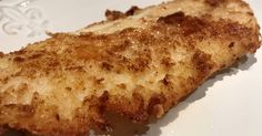 a piece of fried fish sitting on top of a white plate