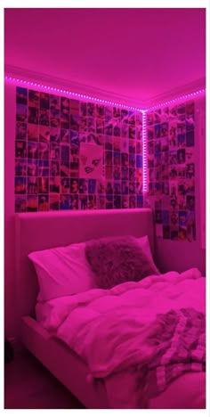 a bedroom with pink lighting and pictures on the wall