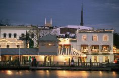 christmas lights adorn buildings along the water's edge