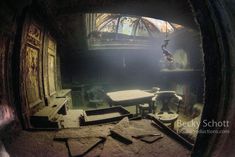 an old room with tables and stools in the center, looking through a fish eye lens