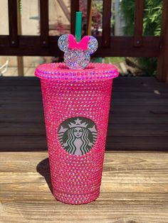 a pink starbucks cup with minnie mouse ears on top