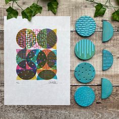 some blue and green circles are on a table next to other items that have been made out of paper