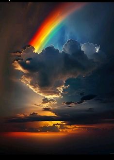 a rainbow in the sky with clouds above it