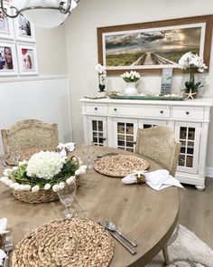 a dining room table with place settings and flowers in baskets on the top of it