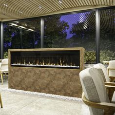 an outdoor fireplace with chairs and tables around it