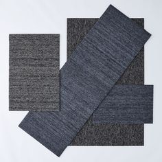 four different colors of fabric laid out on top of each other, one in grey and the other in black