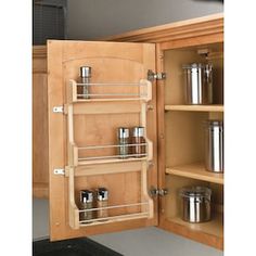 an open cabinet with spice racks in it