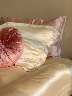 a pink pillow sitting on top of a bed