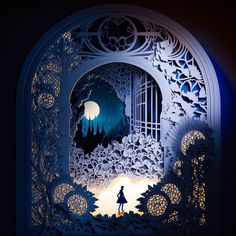 the silhouette of a person standing in front of an intricate paper cut out scene with trees and a full moon