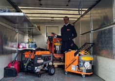 a man standing next to some machines in a garage