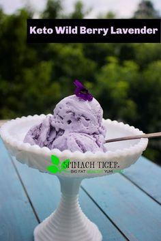 a bowl filled with ice cream sitting on top of a wooden table next to trees