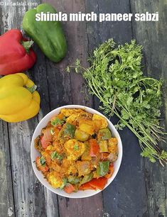 a bowl of food sitting on top of a wooden table next to some veggies