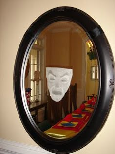 there is a mirror with a mask on it in front of a dining room table