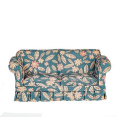 a blue floral couch with ruffles on the arms and back, against a white background