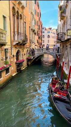 a gondola is parked on the side of a narrow canal