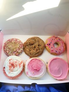 a box filled with lots of different types of doughnuts on top of each other