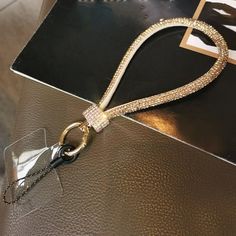 a purse with a chain attached to it on top of a table next to a card holder