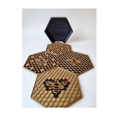 three honeycomb coasters with a bee on the front and one in the back