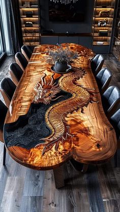 a wooden table with black chairs and a dragon design on the top, in front of a large window