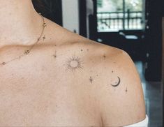 the back of a woman's shoulder with a sun and stars tattoo on it