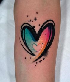 a colorful heart tattoo on the arm