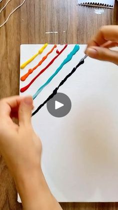 someone is doing something with colored crayons on the paper and then using scissors