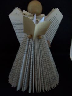 an origami angel reading a book