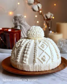 a white cake sitting on top of a wooden plate