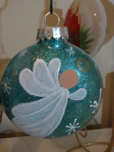 a glass ornament with a white angel painted on it