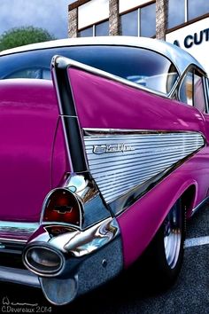 an old purple car parked in front of a building with a sign that reads cutout