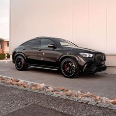 a black mercedes suv parked in front of a building