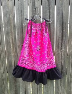 a pink and black dress hanging on a fence