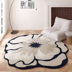 a living room with a large rug on the floor and a chair in front of it