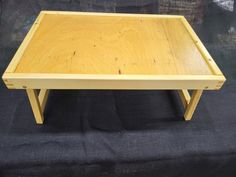 a wooden table sitting on top of a black cloth