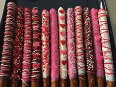 a tray filled with lots of different types of donuts and pretzel sticks