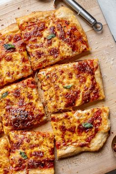 several slices of pizza sitting on top of a wooden cutting board