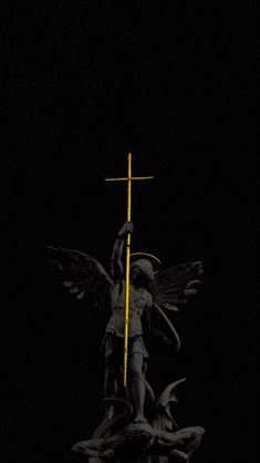 a statue with a cross on top of it in the middle of a dark room